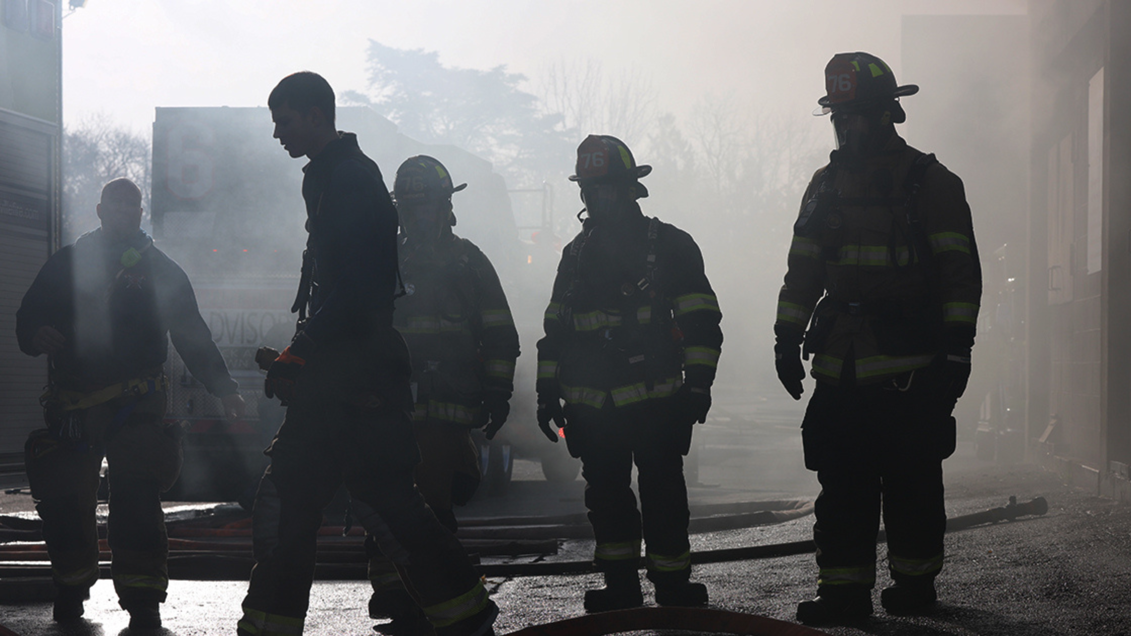 Firefighters standing in the haze after putting a fire out
